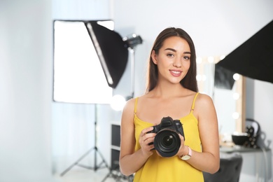 Professional photographer with camera in photo studio