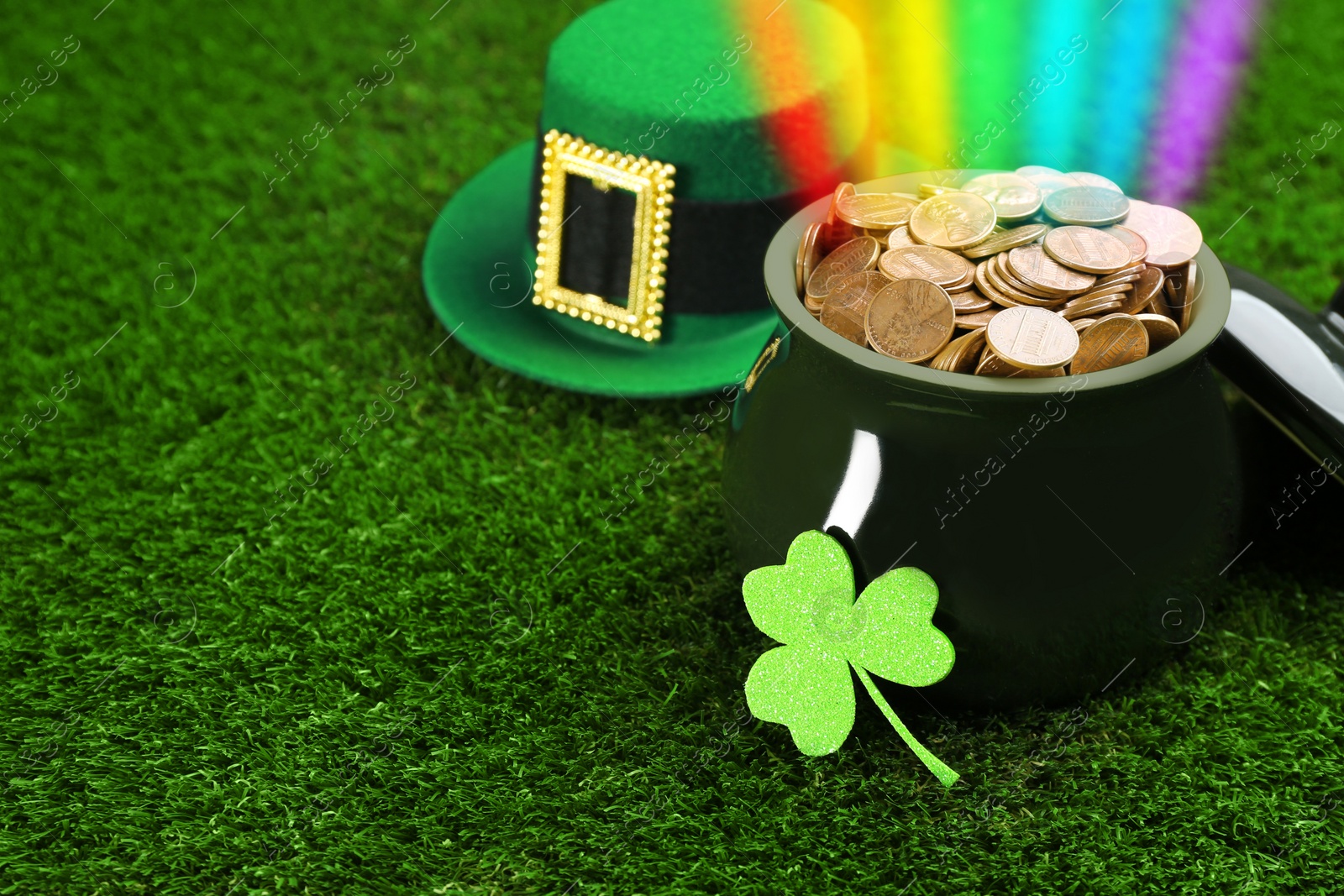 Image of Pot with gold coins, hat and clover on green grass, space for text. St. Patrick's Day celebration