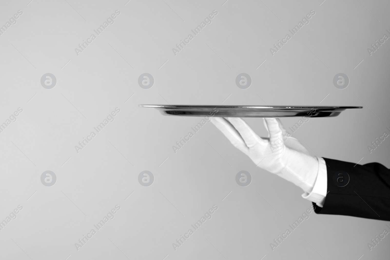 Photo of Butler with tray on light grey background, closeup. Space for text