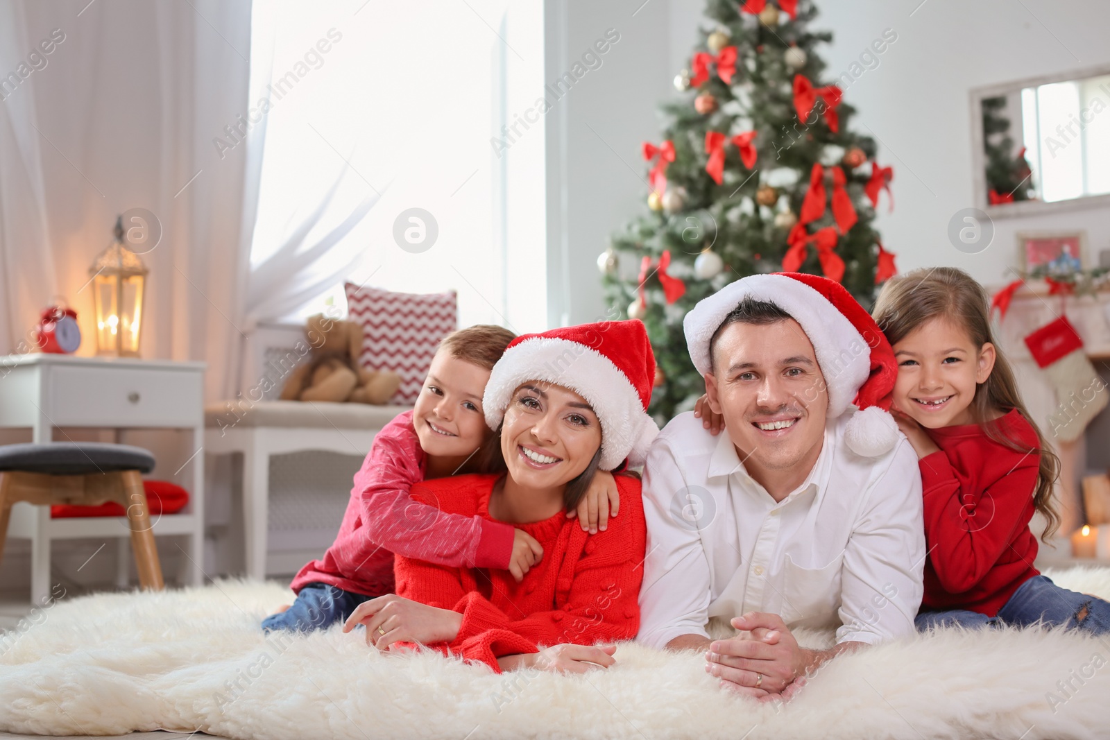 Photo of Happy parents celebrating Christmas with children at home
