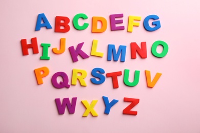 Photo of Plastic magnetic letters on color background, top view. Alphabetical order