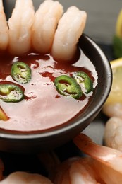 Photo of Tasty boiled shrimps with cocktail sauce, chili and parsley on table, closeup