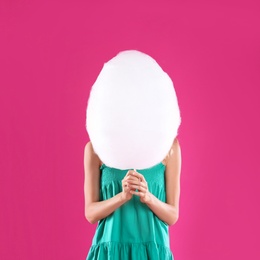 Photo of Young woman with cotton candy on pink background