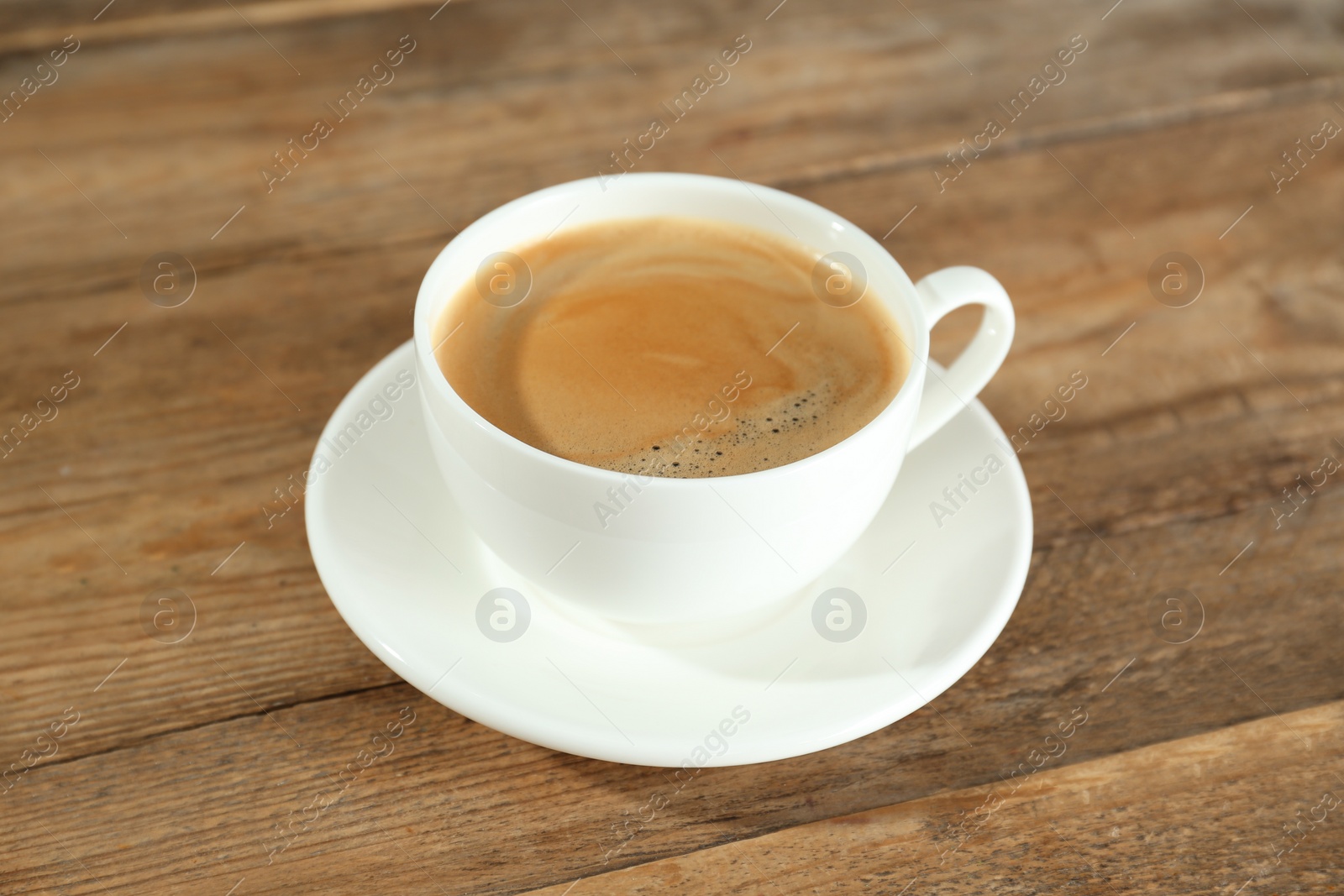 Photo of Cup of tasty coffee on wooden table