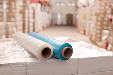 Photo of Rolls of different stretch wraps on boxes in warehouse