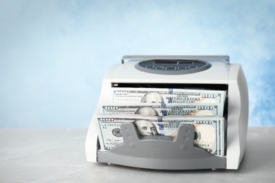 Photo of Modern bill counter with money on table