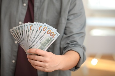 Man with American money on blurred background, closeup
