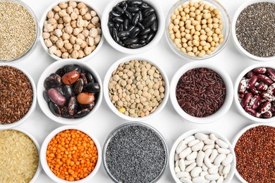 Photo of Various raw veggie seeds in bowls on white background, top view