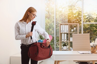 Photo of Beautiful businesswoman with sports bag in office