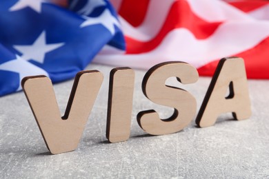 Photo of Word Visa and American flag on light grey table, closeup
