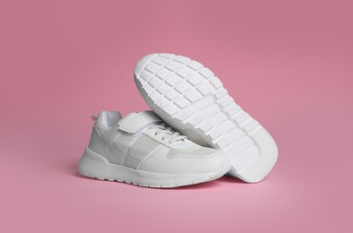 Photo of Pair of stylish sneakers on pink background