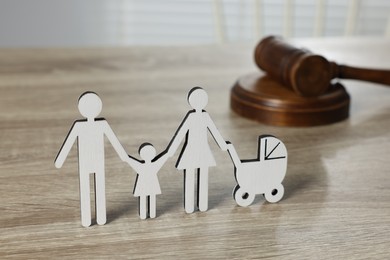 Photo of Family law. Figure of parents with children and gavel on light wooden table