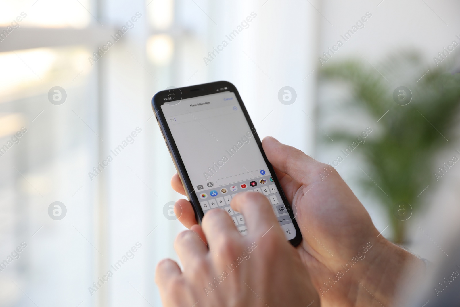 Photo of MYKOLAIV, UKRAINE - MARCH 16, 2020: Man typing message on iPhone 11 indoors, closeup