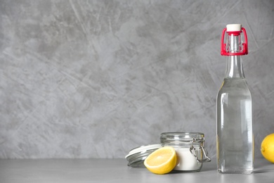 Composition with vinegar, lemon and baking soda on table. Space for text