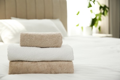 Soft clean towels on bed at home