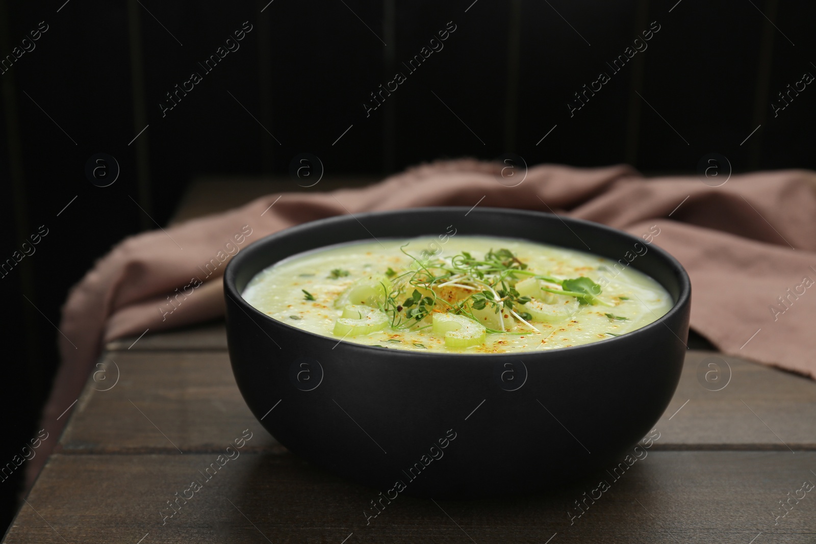 Photo of Bowl of delicious celery soup on wooden table