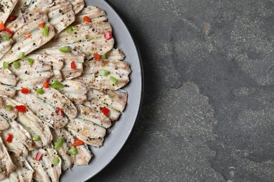 Tasty pickled anchovies with spices on grey textured table, top view. Space for text