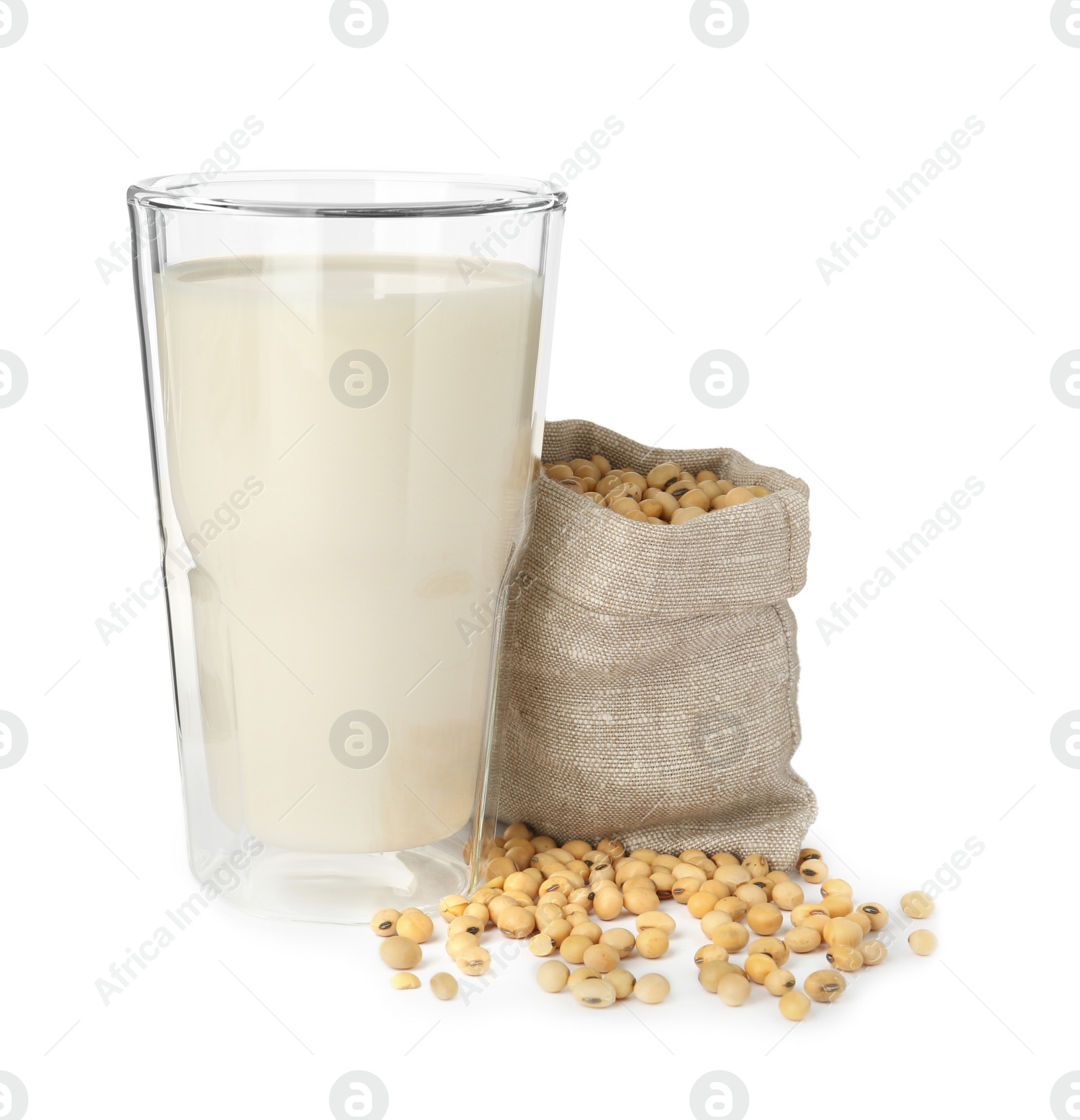 Photo of Glass of fresh soy milk and sack bag with beans on white background