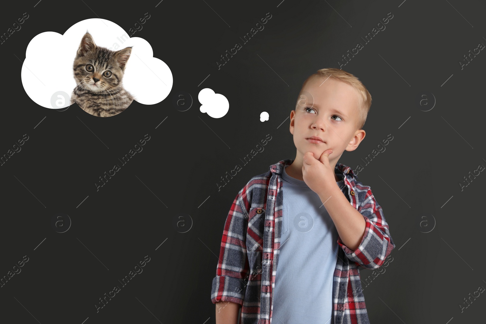 Image of Little boy on dark background dreaming about cute kitten