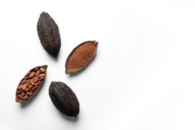 Cocoa pods with beans and powder on white background, top view