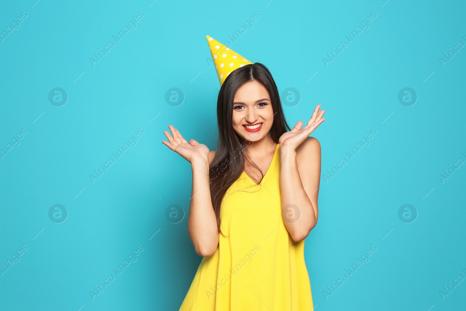 Photo of Young woman with party cap on color background. Birthday celebration