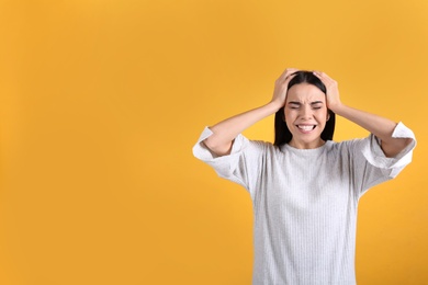 Photo of Portrait of stressed young woman on yellow background. Space for text