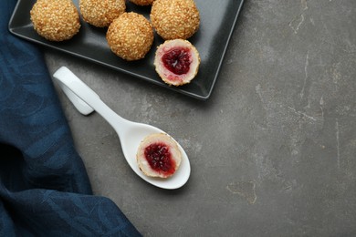 Photo of Delicious sesame balls with on grey table, flat lay