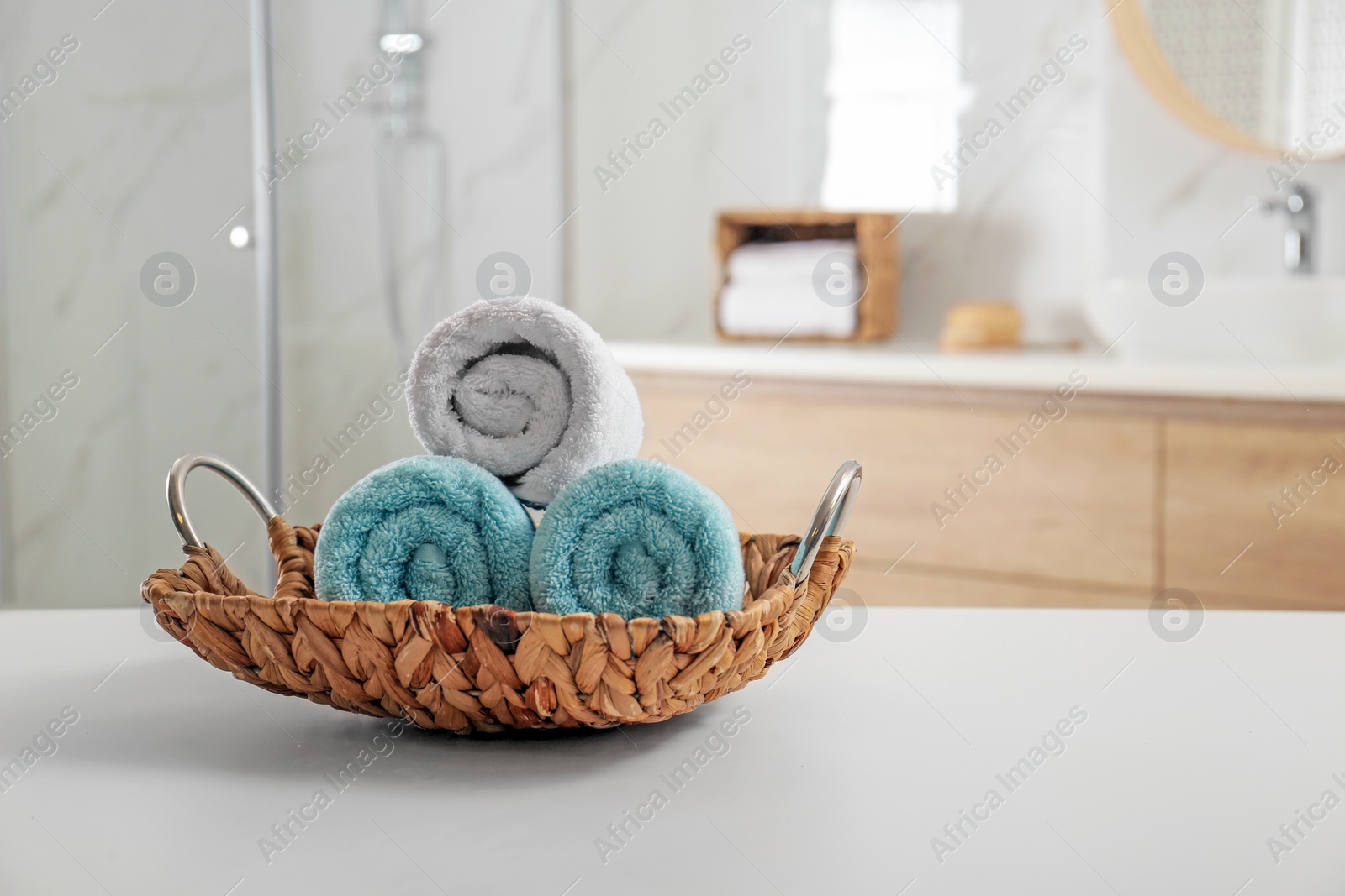Photo of Wicker tray with clean soft towels in bathroom. Space for text