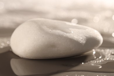 White spa stone with water drops on grey background, closeup