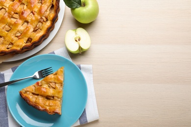 Traditional apple pie and fresh fruits on wooden table, flat lay. Space for text