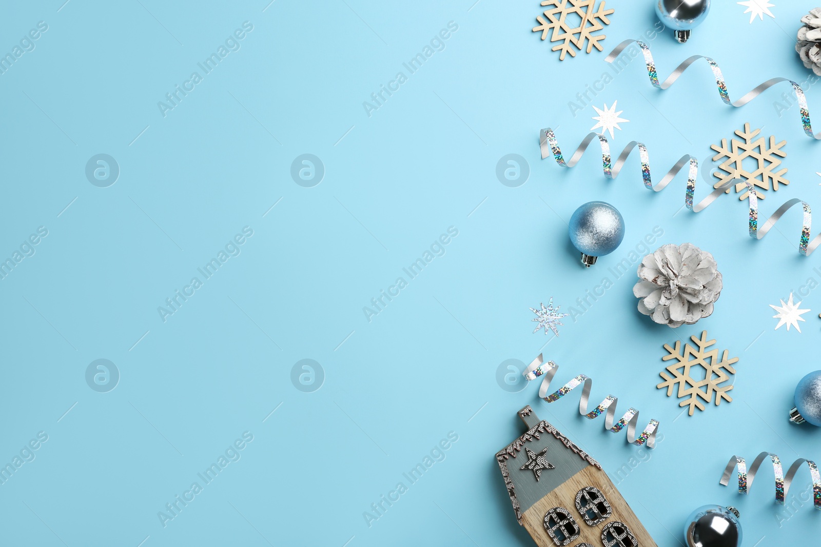 Photo of Flat lay composition with serpentine streamers and Christmas decor on light blue background. Space for text