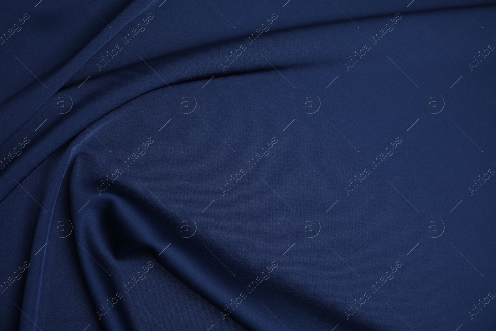 Photo of Crumpled dark blue silk fabric as background, top view. Space for text