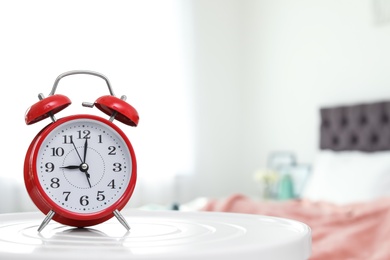 Photo of Alarm clock on table in bedroom. Time to wake up