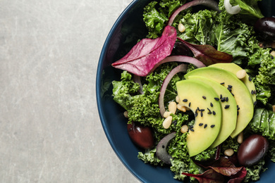 Photo of Tasty fresh kale salad on light grey table, top view. Space for text