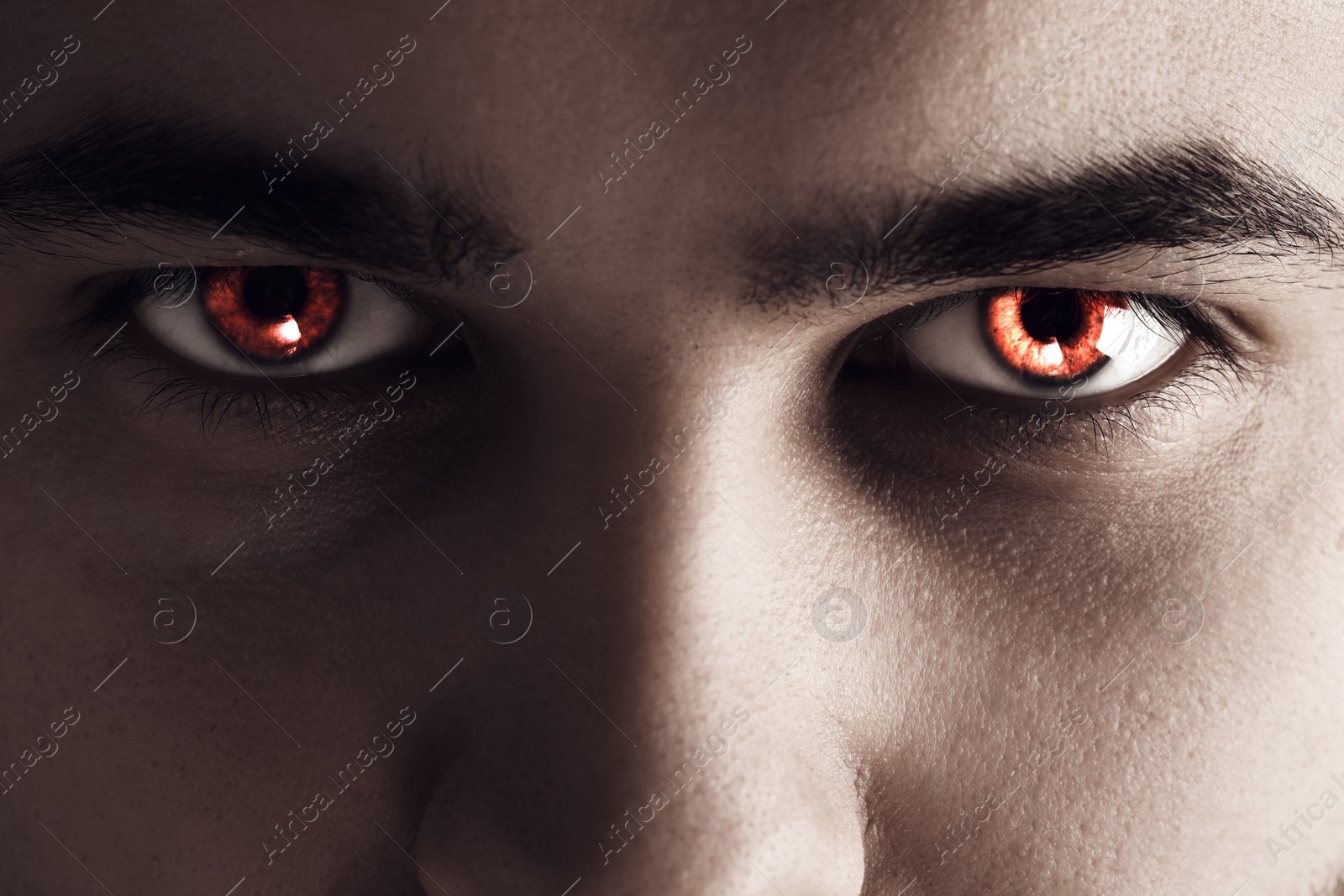 Image of Evil eye. Man with red demonic eyes, closeup