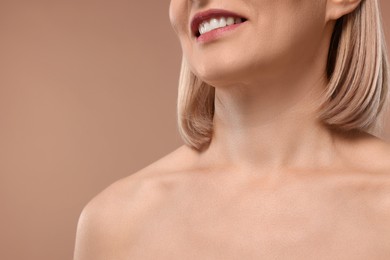 Woman with healthy skin on beige background, closeup