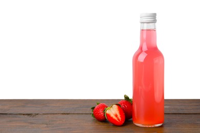 Photo of Delicious kombucha in glass bottle and strawberries on wooden table against white background, space for text