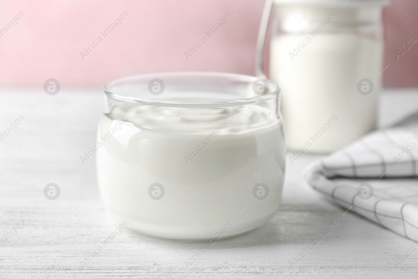 Photo of Glass jar tasty with yogurt on wooden table