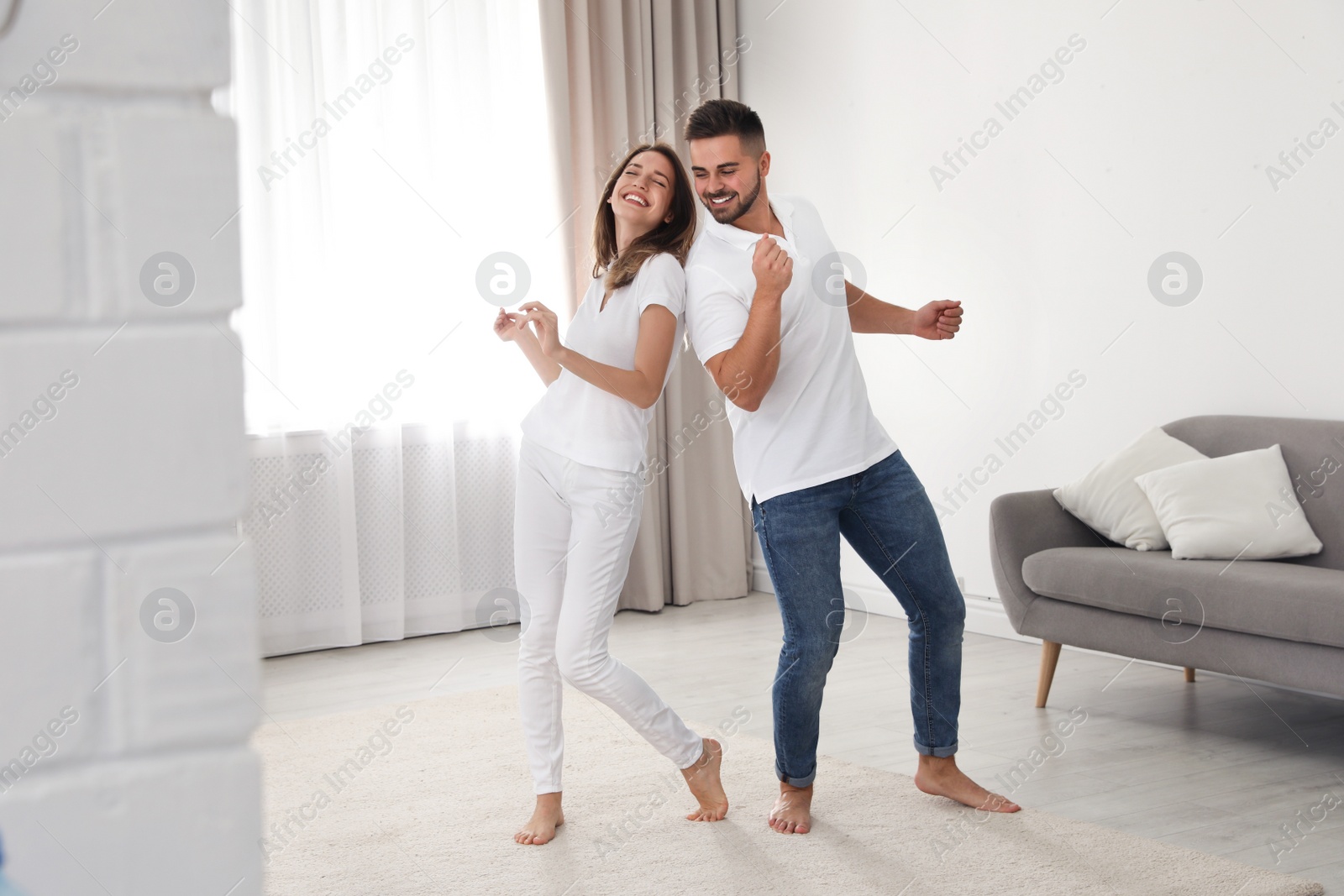 Photo of Lovely young couple dancing together at home