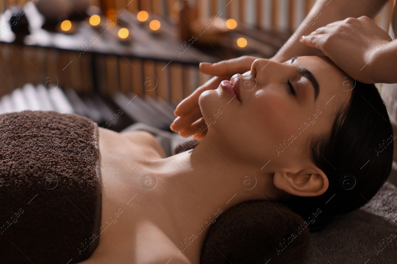 Photo of Spa therapy. Beautiful young woman lying on table during massage in salon