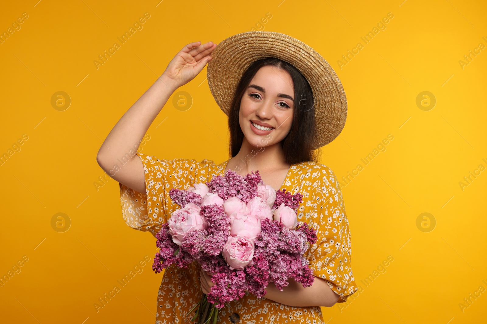 Photo of Beautiful woman with bouquet of spring flowers on yellow background