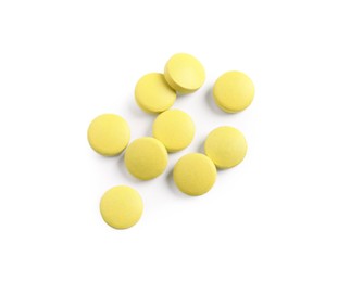 Photo of Many yellow pills isolated on white, top view