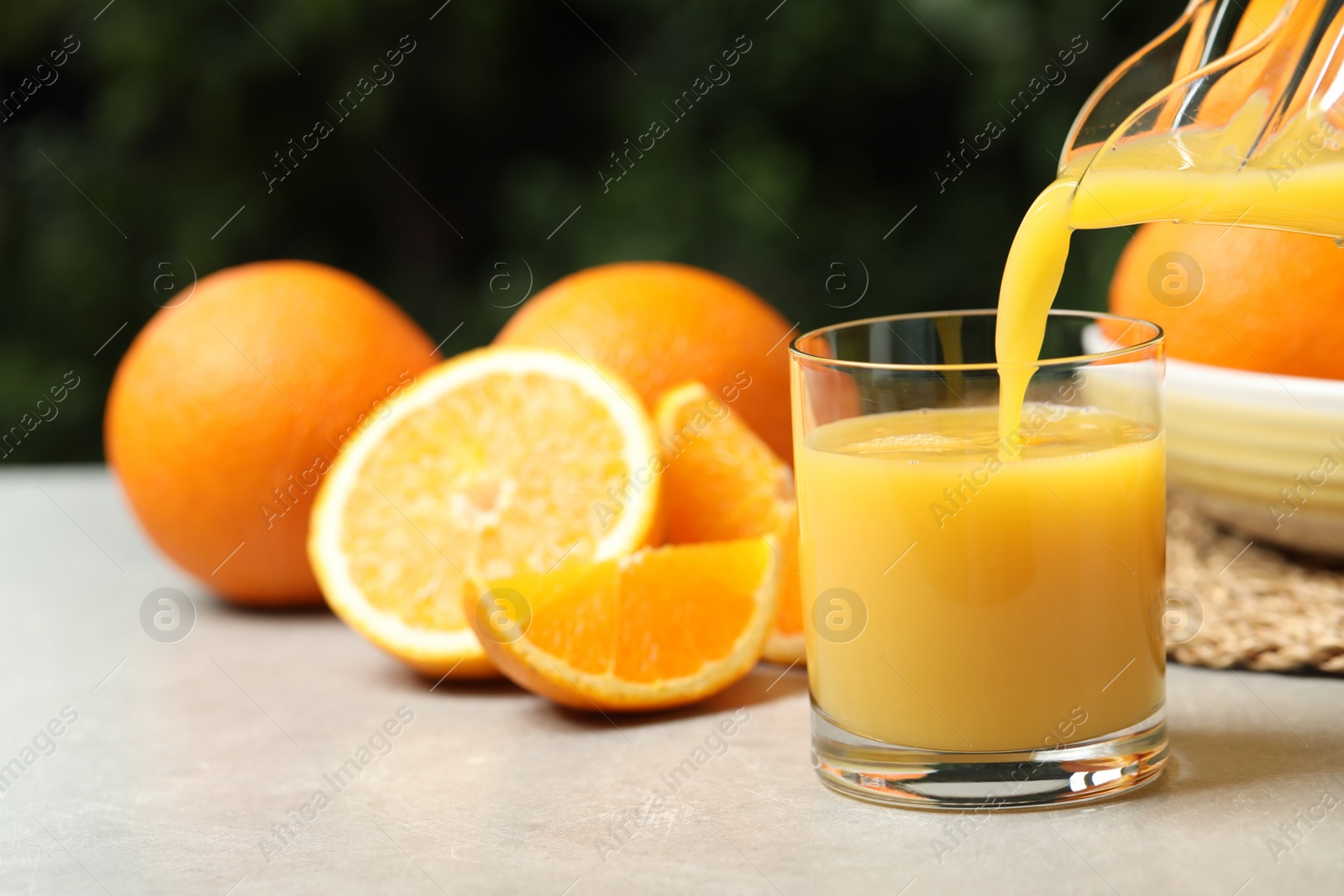 Photo of Pouring orange juice into glass at light table