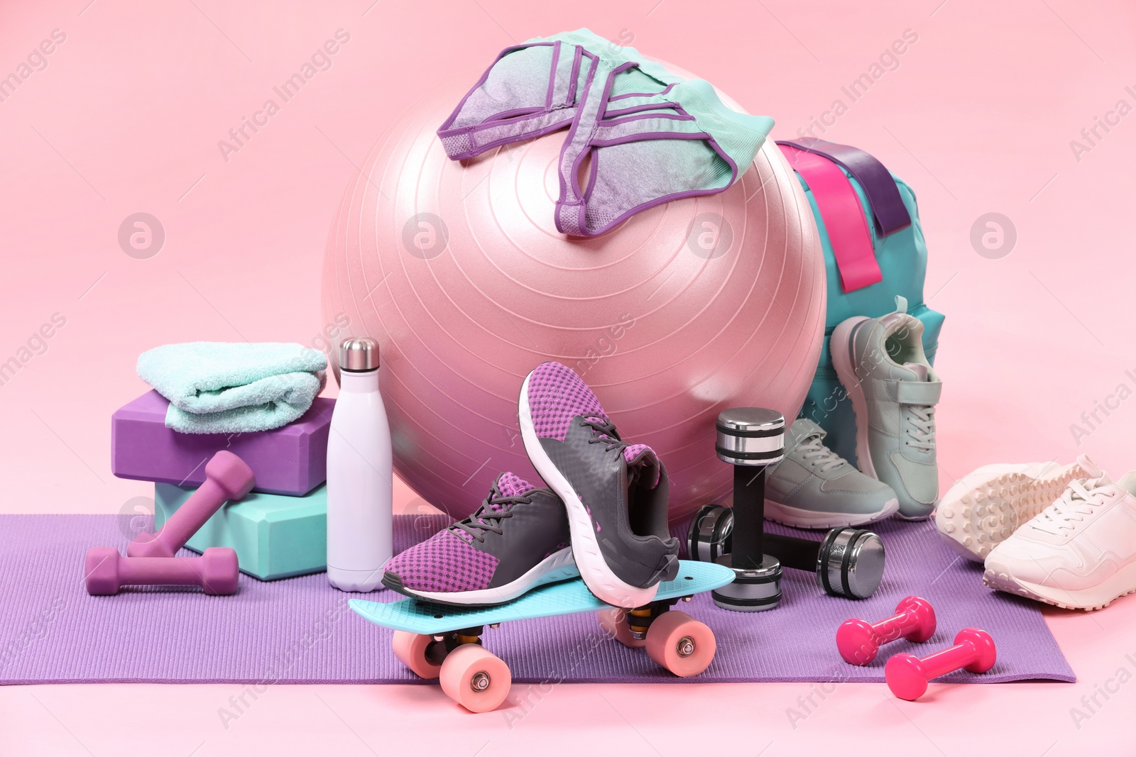 Photo of Many different sports equipment on pink background