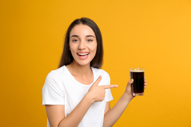 Photo of Beautiful woman with cold kvass on yellow background. Traditional Russian summer drink