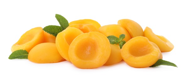 Photo of Sweet canned peach halves with mint isolated on white