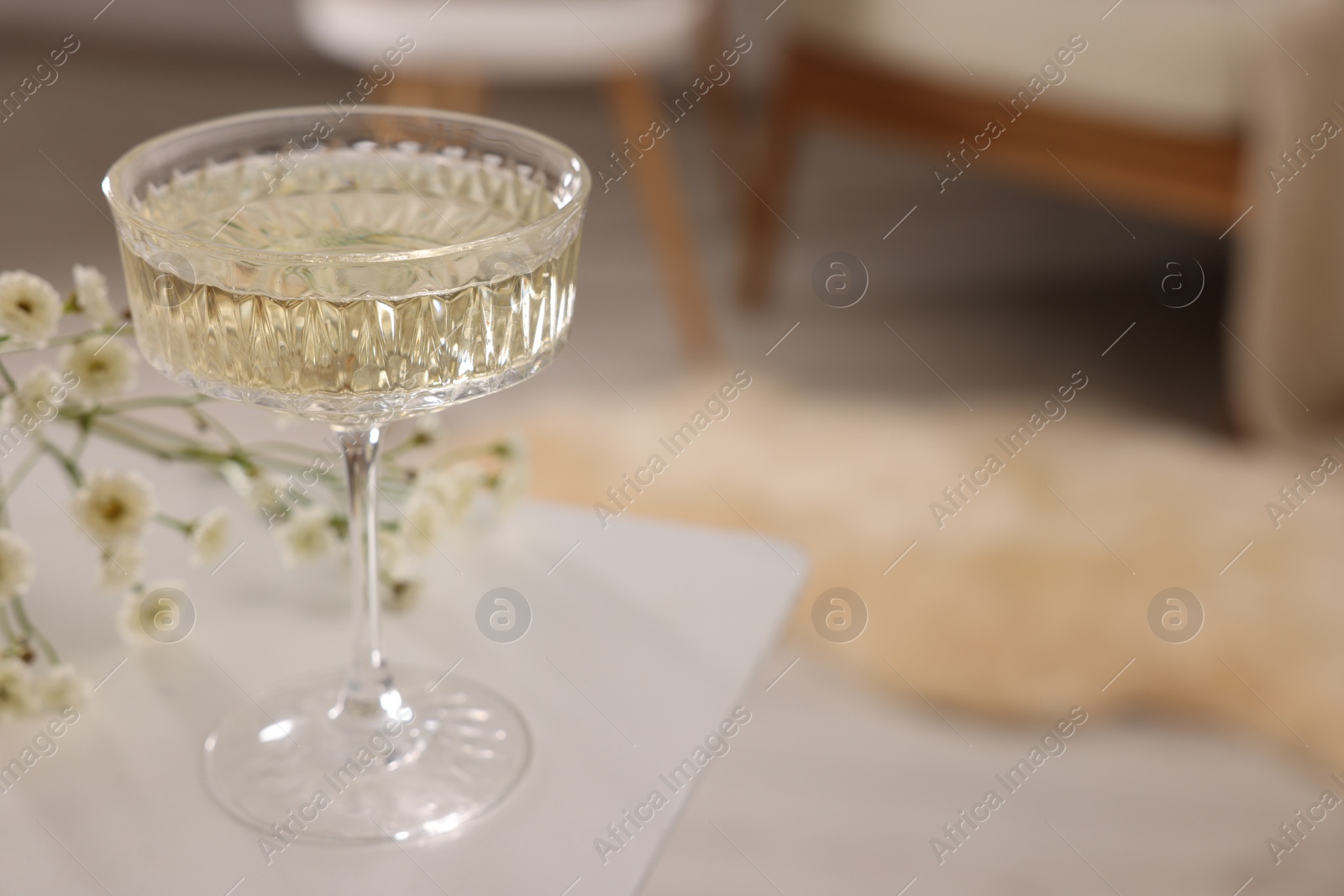 Photo of Glass of alcohol drink on table in room, closeup and space for text. Relax at home
