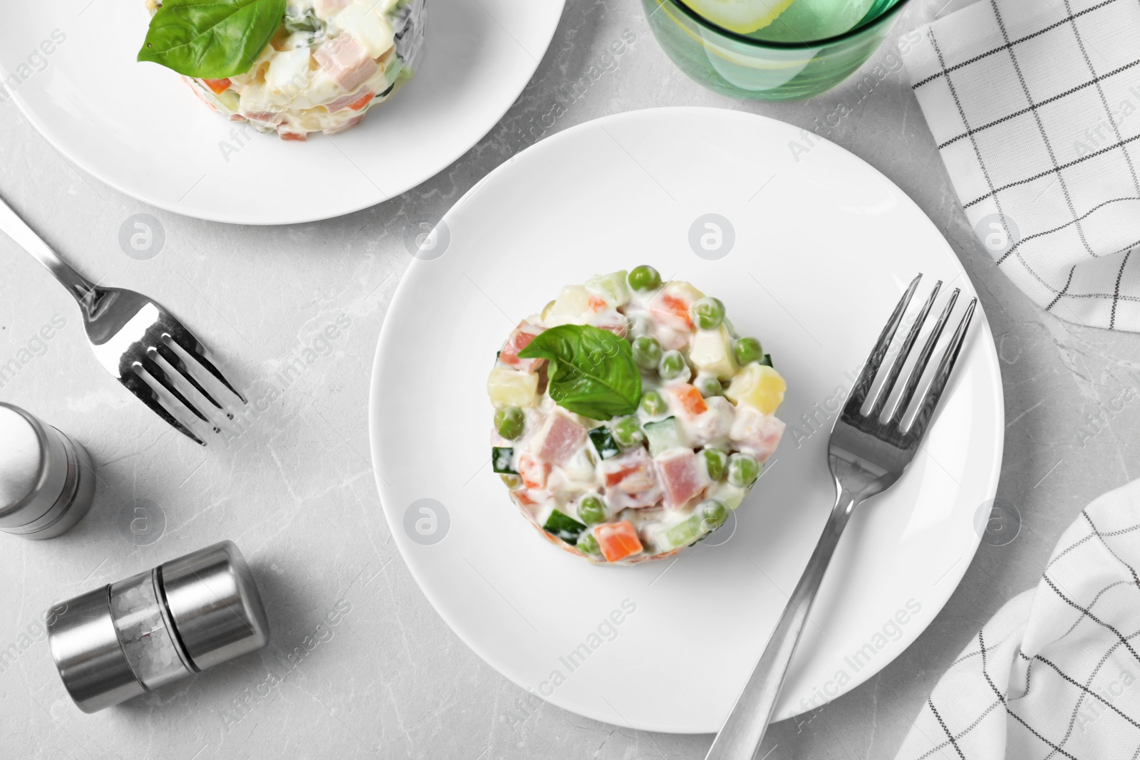 Photo of Delicious salad Olivier on light table, flat lay