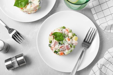 Photo of Delicious salad Olivier on light table, flat lay