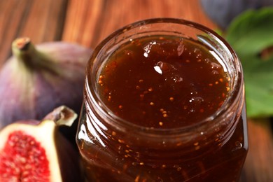 Photo of Jar of tasty sweet jam and fresh figs on table, closeup